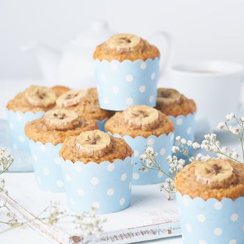 Banana muffin, cupcakes in blue cake cases paper, side view. Morning breakfast on a white concrete table