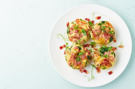egg muffins with spinach and bacon, ketogenic keto diet low carb, pastel and modern background closeup copy space