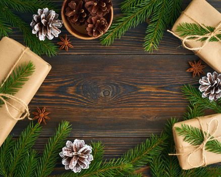 Christmas and Happy New Year zero waste backdrop. Dark wooden table. Handmade gift Christmas box, green fir branches, craft paper , top view, copy space. Ecofriendly plastic free concept