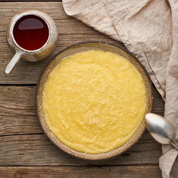 porridge polenta with cup of tea, dark wood background, top view