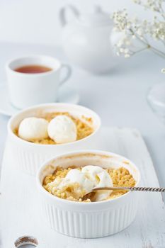Apple crumble, spoon with ice cream, streusel. Side view, vertical. Morning breakfast.
