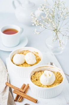 Apple crumble with streusel, tea, cinnamon on light gray table. Vertical.