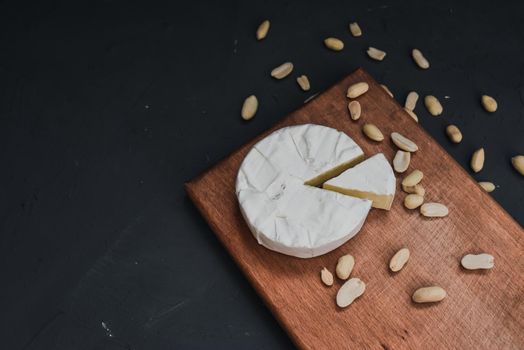 cheese camembert with mold and nuts on the wooden cutting board