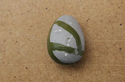 Stone decorative egg of gray color with stripes.