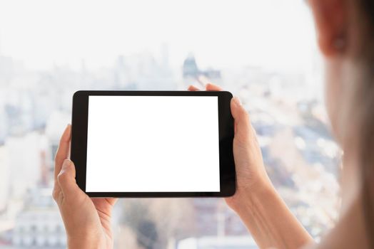 hands holding tablet with defocused background