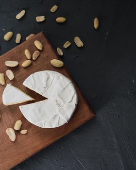 cheese camembert with mold and nuts on the wooden cutting board