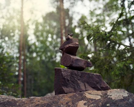 pyramid of stones, a symbol of the wild Northern nature of Karelia. Coniferous forest with sunlight