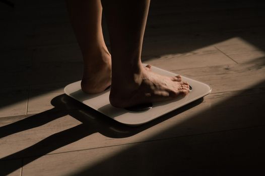 Close-up of female legs on electronic scales