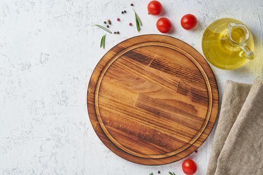Spices, Herbs and a round wooden cutting board on white concrete backdrop. Top view, copy space. Menu, recipe, mock up, banner. Food seasoning background.