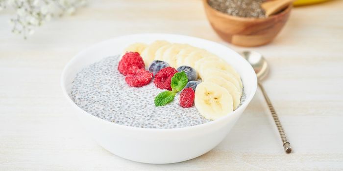 Banner with Chia pudding in bowl with fresh berries raspberries, blueberries. Side view, white wooden light background