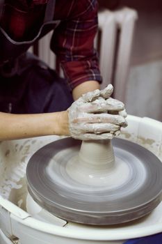 Woman making ceramic pottery on wheel, hands closeup. Concept for woman in freelance, business, creative hobby. Earn extra money, side hustle