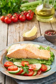 Steam salmon and vegetables, Paleo, keto, fodmap diet. Side view, vertical. Healthy diet concept, blue plate on old rustic wooden table