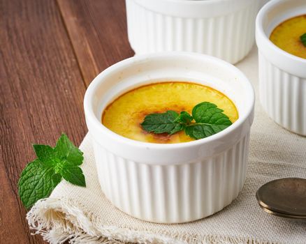 Crema catalana, Spanish dessert on brown wooden table, macro, close up, side view