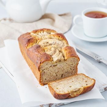 Banana bread, cake with banana, side view, vertical. The morning Breakfast with tea on light grey background