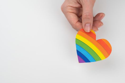 Female hands with rainbow paper heart isolated on white background. Copy space