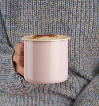 hands holding a cup of hot chocolate, gray cozy sweater, beautiful pink manicure, home style, autumn morning, close up