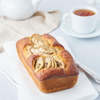 Banana bread, cake with banana, side view. The morning Breakfast with tea on light grey background