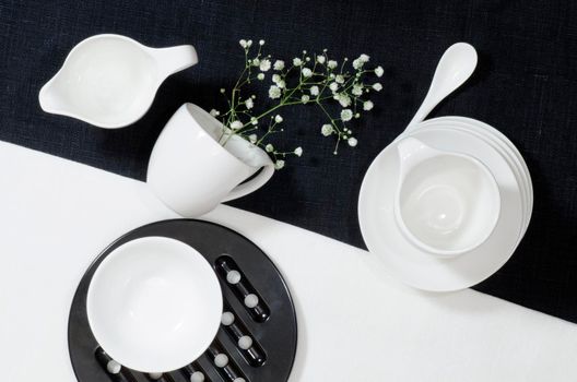 White porcelain on black and white linen tablecloths. White porcelain on black and white linen tablecloths. Abstract still life. From series "Playing with Color"