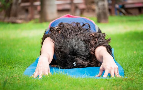 Close up of girl doing stretching yoga, girl doing bharata yoga, young woman doing stretching yoga outdoors