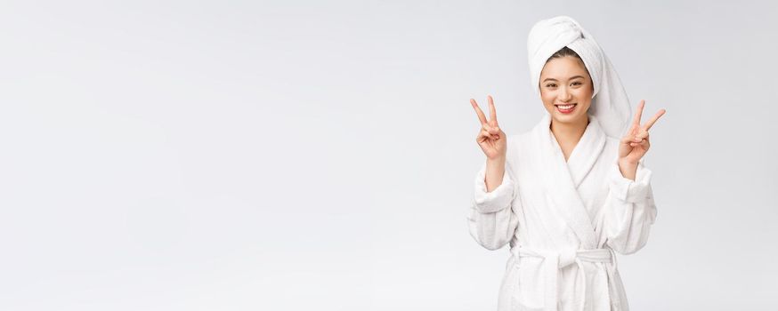 Beautiful asian woman showing peace sign or two finger with happy feeling. Isolated over white background