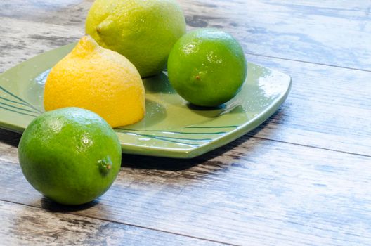 Lemons and limes on a green plate. From the series "Healthy Eating"