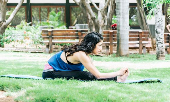 A girl doing stretching yoga, girl doing bharata yoga, young woman doing stretching yoga outdoors