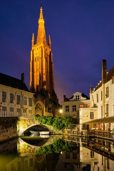 Church of Our Lady and canal illuminated in the night. Brugge Bruges, Belgium