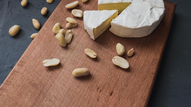 cheese camembert with mold and nuts on the wooden cutting board