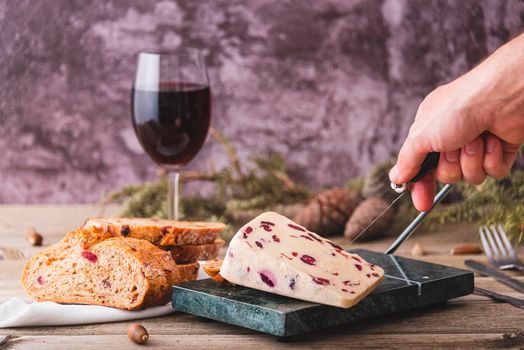 Wensleydale cheese with cranberries on a marble cheese cutting table
