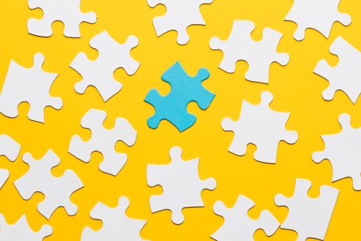 blue puzzle with white jigsaw piece yellow background