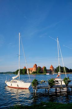 Yacht boats and Trakai Island Castle in lake Galve in day, Lithuania. Trakai Castle is one of major tourist attractions of Lituania