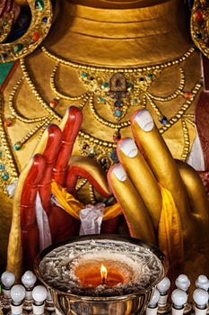 Maitreya Buddha hands with burning lampion in Thiksey Gompa. Ladakh, India