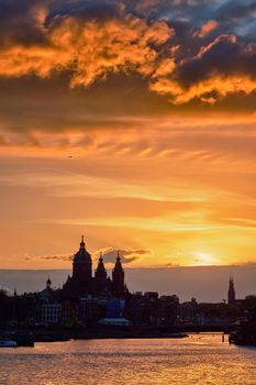 Amsterdam cityscape skyline with Church of Saint Nicholas (Sint-Nicolaaskerk) on sunset with dramatic sky. Amsterdam, Netherlands