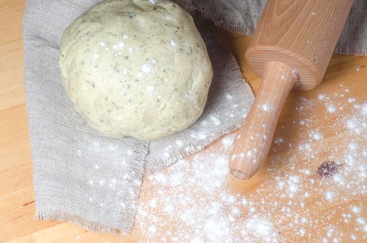 Dough, rolling pin and flour on a wooden table. From series "Cooking vegetable pie"