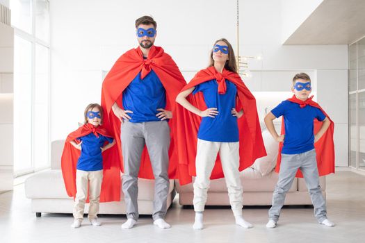 Portrait of family pretending to be superhero in living room at home