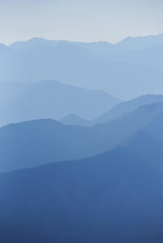 Blue mountain range silhouette with morning haze.