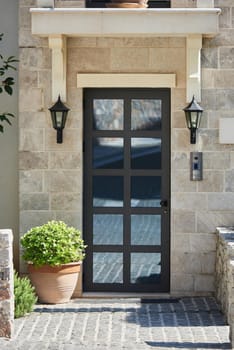 Modern house facade with stone finished wall and glass door.