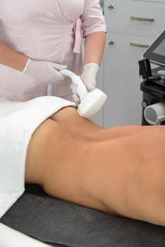Laser hair removal on mans back. therapist in a pink t-shirt