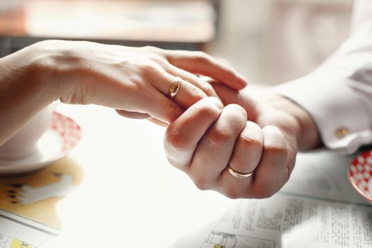 bride and groom holding hands in a cafe