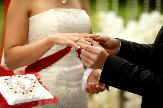 Close up on hand of a man put on an engagement ring on the finge