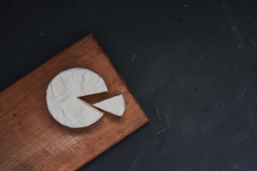 cheese camembert with mold on the wooden cutting board