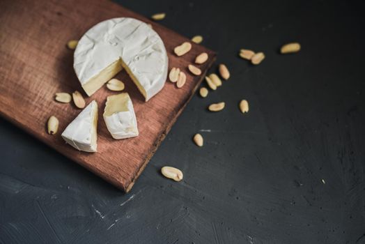 cheese camembert with mold and nuts on the wooden cutting board