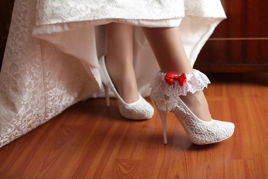 A white linen garter with a red bow.