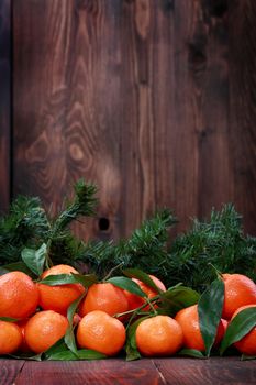 Tangerines with leaves on wooden surface. Citrus fruit