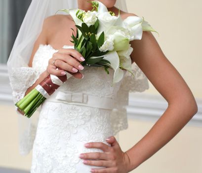 Young beautiful bride waits for groom near the window