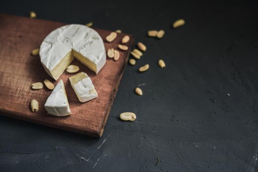 cheese camembert with mold and nuts on the wooden cutting board