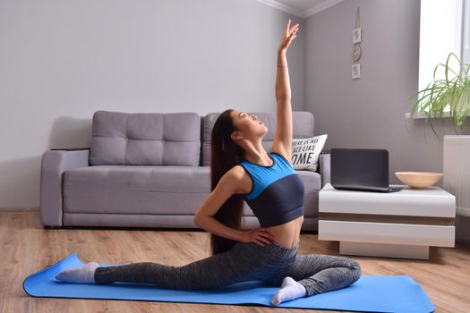 Young asian woman making yoga at home. Carantin and hobby. Home isolation. Online training. Soft focus