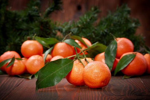 Tangerines with leaves on wooden surface. Citrus fruit