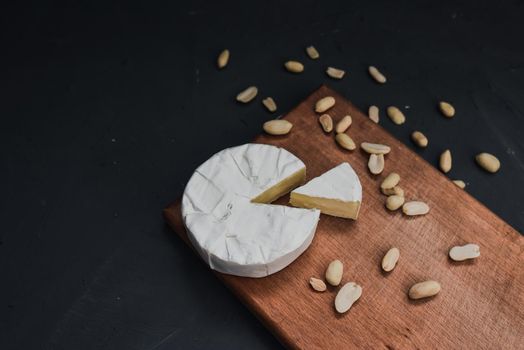 cheese camembert with mold and nuts on the wooden cutting board