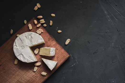 cheese camembert with mold and nuts on the wooden cutting board